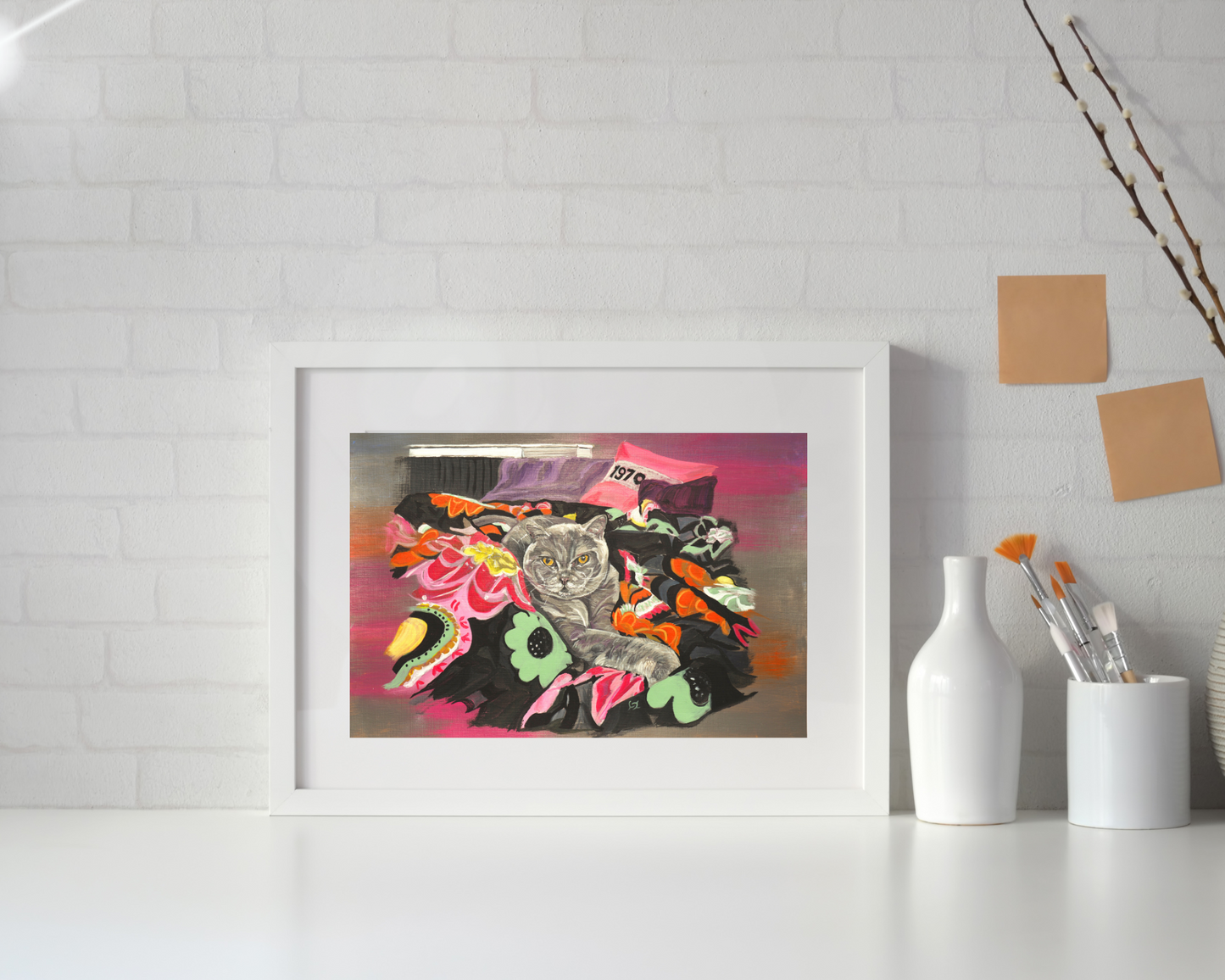 Cat on Throw wall art print in white mount and white frame resting on work surface