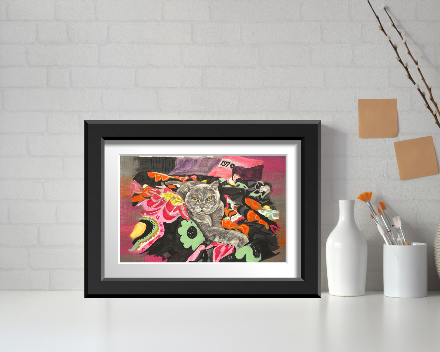 Cat on Throw wall art print in white mount and black frame mockup resting on worktop