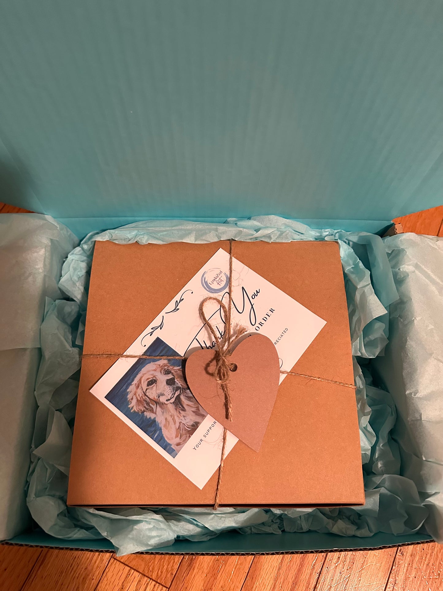 Packaging for Mug and Coaster set box tied with twine and heart tag inside package box with pale blue lining and tissue